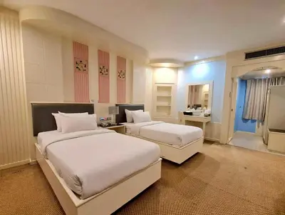 a hotel room with two beds and a bathroom at The Rich Hotel Rama 5 in Ban Bang Phai