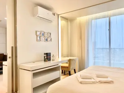 a white bedroom with a desk and a bed at Sathorn Prime Residence 1BR #Bangkok in Bangkok