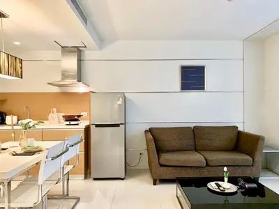 a kitchen and living room with a couch and a table at Sathorn Prime Residence 1BR #Bangkok in Bangkok
