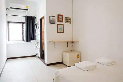 a white room with two beds and a window at XX GO INN Asiatique BKK - โกอินน์ เอเชียทีค เจริญกรุง in Godown