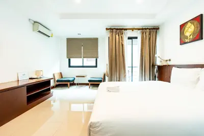 a hotel room with a white bed and a desk at YON INN Sukhumvit 4 BTS Nana in Bangkok