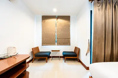 a room with two chairs and a desk and a window at YON INN Sukhumvit 4 BTS Nana in Bangkok