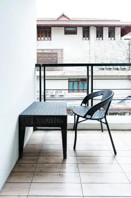 a bench on a balcony with a view of a building at YON INN Sukhumvit 4 BTS Nana in Bangkok