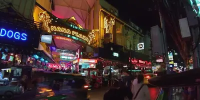a busy city street at night with neon signs at YON INN Sukhumvit 4 BTS Nana in Bangkok