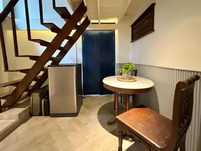 a small room with a table and a staircase at Non Inn Entire Historic 5 Bedroom Riverside Shophouse near ICONSIAM for Families and Groups in Bang Rak