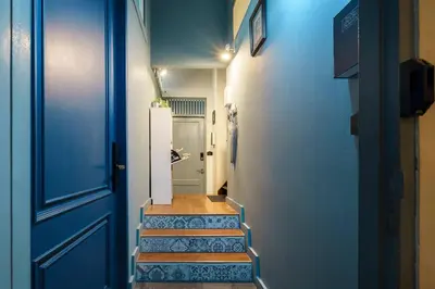 a hallway with blue walls and stairs with a blue door at Non Inn The Post Spacious King Room with Sofa Bed and Living Area near Riverside and ICONSIAM in Bang Rak