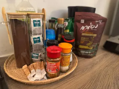 a basket with spices and a bag on a table at Non Inn The Post Spacious King Room with Sofa Bed and Living Area near Riverside and ICONSIAM in Bang Rak