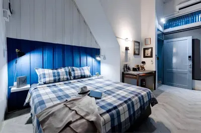 a blue and white bedroom with a bed and a sink at Non Inn The Barber King and Twin Rooms with Vintage Charm and Unique Design near Riverside and ICONSIAM in Bang Rak