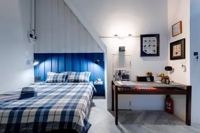 a bedroom with a blue and white bed and a desk at Non Inn The Barber King and Twin Rooms with Vintage Charm and Unique Design near Riverside and ICONSIAM in Bang Rak