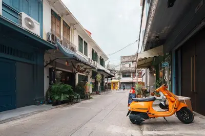 an orange scooter parked on the side of a street at Non Inn The Diamond Artisan and Barber 4 Bedroom Riverside Retreat with King and Twin Rooms in Bang Rak