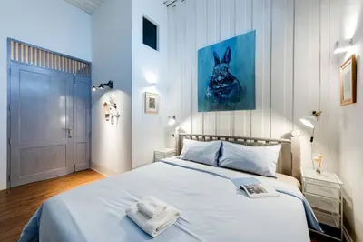 a bedroom with a bed with a blue painting on the wall at Non Inn The Diamond Artisan King and Twin Rooms with Private Coffee Station and InnerCourt Quiet View near Riverside and ICONSIAM in Bang Rak