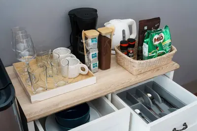 a shelf with wine glasses and other items on it at Non Inn The Diamond Artisan King and Twin Rooms with Private Coffee Station and InnerCourt Quiet View near Riverside and ICONSIAM in Bang Rak
