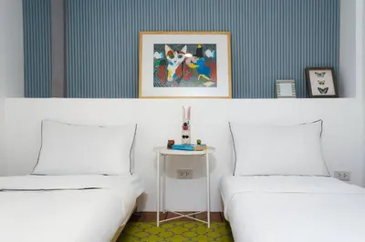 two white beds in a room with a table at Non Inn The Diamond Artisan King and Twin Rooms with Private Coffee Station and InnerCourt Quiet View near Riverside and ICONSIAM in Bang Rak