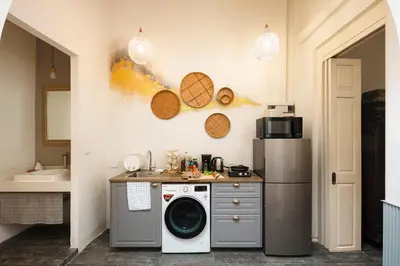 a kitchen with a washing machine and a sink at Non Inn The Post and Barber 3 Bedroom Riverside Shophouse with King and Twin Rooms in Bang Rak