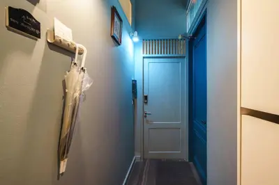 a hallway with a blue wall and a door at Non Inn The Post and Barber 3 Bedroom Riverside Shophouse with King and Twin Rooms in Bang Rak