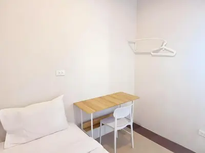 a bedroom with a bed and a table and a chair at XX The Hidden Khaosan - เดอะ ฮิดเด้น ข้าวสาร รามบุตรี 7 in Bang Bua Thong Railway Station