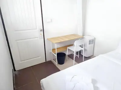 a small room with a desk and a white door at XX The Hidden Khaosan - เดอะ ฮิดเด้น ข้าวสาร รามบุตรี 7 in Bang Bua Thong Railway Station