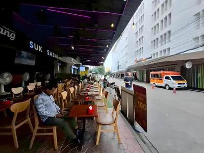a group of people sitting at tables in a restaurant at XX The Hidden Khaosan - เดอะ ฮิดเด้น ข้าวสาร รามบุตรี 7 in Bang Bua Thong Railway Station