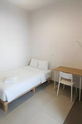 a bed in a room with a table and a chair at XX The Hidden Khaosan - เดอะ ฮิดเด้น ข้าวสาร รามบุตรี 7 in Bang Bua Thong Railway Station