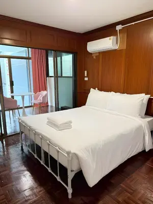 a large white bed in a room with a table at Stay On Sukhumvit Soi 11 - สเตย์ ออน สุขุมวิท 11 in Makkasan