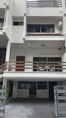 a white building with tables and chairs in front of it at Stay On Sukhumvit Soi 11 - สเตย์ ออน สุขุมวิท 11 in Makkasan