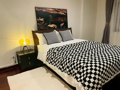 a bedroom with a black and white checkered bed at Private Pool Villas Sukhumvit 26 Near BTS Phrom Phong and EmSphere in Bangkok
