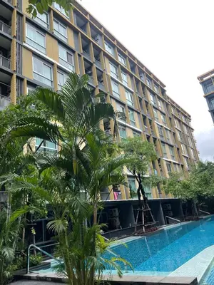 a hotel with a palm tree in front of a building at Welcome to warm room here have gym saona Netflix in Bangkok