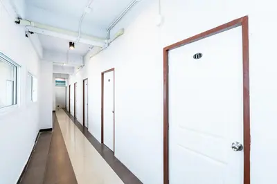 a hallway with white walls and a door at xx เดอะ ฮิดเด้น ตรอก ข้าวสาร The Hidden Khaosan in Bangkok