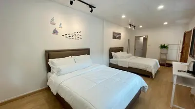 a hotel room with two beds and a desk at Baan Yard - More than 5 nights stay in Bangkok