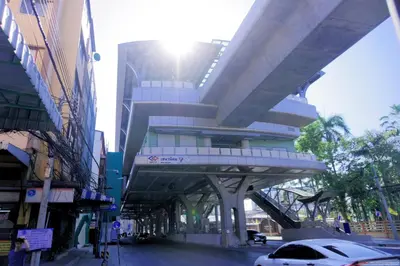 a building with an overhead walkway on a city street at Baan Yard - More than 5 nights stay in Bangkok