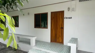 a house with a wooden door and a bench at Baan Yard - More than 5 nights stay in Bangkok