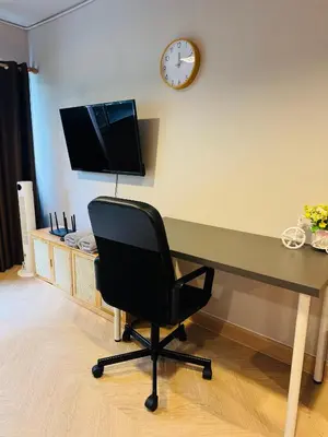a desk with a chair and a clock on the wall at MoonStay C5 Impactarena-Donmuang-FreeSpeedWifi in Thung Si Kan