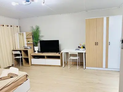 a white living room with a desk and a television at MoonStay C1 Impact Arena Muangthongthani-Donmuang-FreeSpeedWifi in Nonthaburi