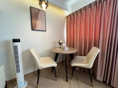 a table and chairs in a room with a curtain at Lazy House at Impact Muangthong in Thung Si Kan