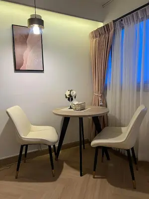 a table and two chairs and a table with flowers on it at Lazy House at Impact Muangthong in Thung Si Kan