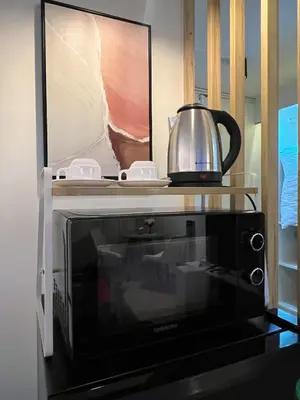 a microwave with a tea kettle on top of it at Lazy House at Impact Muangthong in Thung Si Kan