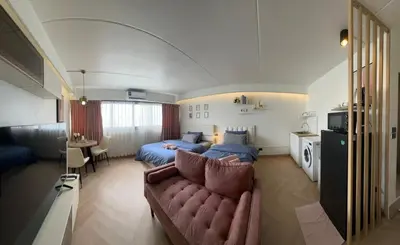 a living room with a couch and a bed at Lazy House at Impact Muangthong in Thung Si Kan