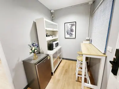 a small kitchen with a refrigerator and a desk in a room at Cozy Private Family Apartment in Bangkok CBD Silom-Sathorn - 240m to BTS Saint Louis in Yan Nawa