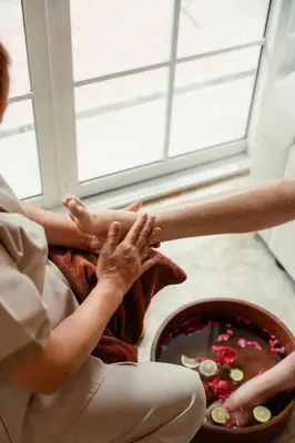 a woman sitting on the floor with her hands in a bowl of liquid at House of Patcha เรือลพัชชา Hostel share bathroom in Bangkok
