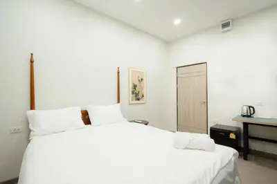 a white bedroom with a large bed and a desk at HD China Town MRT Dragon Temple กลางเยาวราช in Bangkok