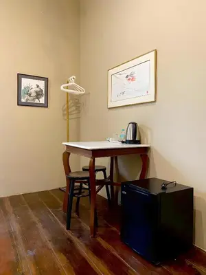 a table in a room with a desk and a lamp at xx Rest Inn Yaowarat เรสอินน์ เยาวราช in Samphanthawong