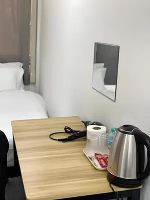 a wooden table with a tea kettle on it next to a bed at xx GO INN Siriraj BKK - โกอินน์ โรงพยาบาล ศิริราช in Bangkok Noi