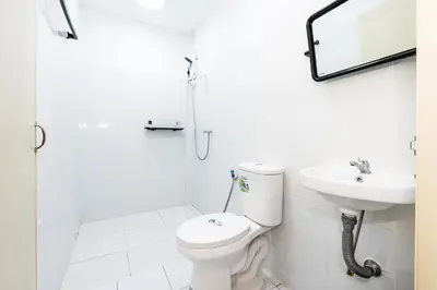 a white bathroom with a toilet and a sink at xx GO INN Siriraj BKK - โกอินน์ โรงพยาบาล ศิริราช in Bangkok Noi
