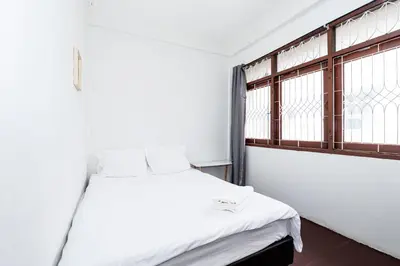a white bed in a room with a window at xx GO INN Siriraj BKK - โกอินน์ โรงพยาบาล ศิริราช in Bangkok Noi