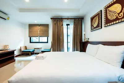 a bedroom with a large white bed and a desk at XX YON INN Sukhumvit 4 Bangkok - BTS Nana in Bang Kapi