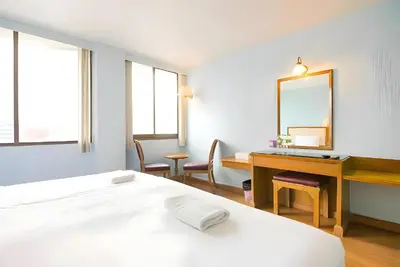 a bedroom with a bed and a desk and a mirror at XX Wish Inn Chidlom - วิช อินน์ ชิดลม in Bangkok