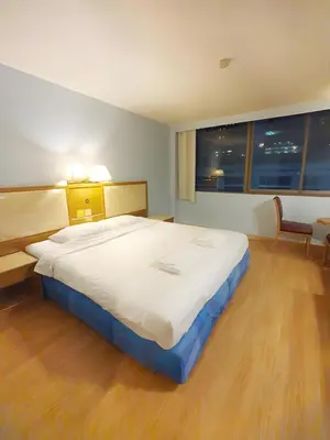a large bed in a room with a large window at XX Wish Inn Chidlom - วิช อินน์ ชิดลม in Bangkok