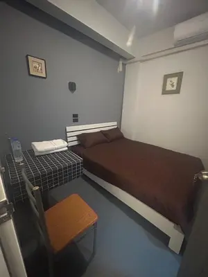 a room with two beds and a table and a chair at Capricorn hostel Yaowarat in Chinatown