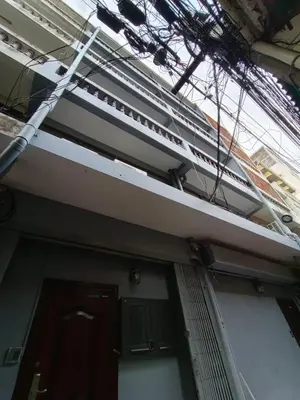 a view of a building with a ladder on it at Capricorn hostel Yaowarat in Chinatown
