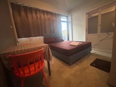 a bedroom with a bed and a table and a chair at Capricorn hostel Yaowarat in Chinatown